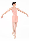 Adult dancer in pink mesh wrap skirt extending arms in a turn, showing movement and flow.