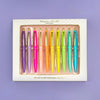 Set of ten colorful motivational pens arranged inside a white gift box on a purple background.