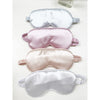 Assorted Love and Repeat satin eye masks stacked in soft neutral and pastel colors
