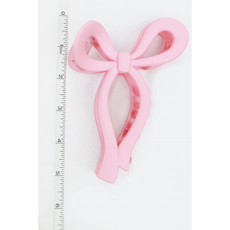 Pink Love and Repeat matte bow hair claw shown upright
