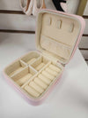 Open pink jewelry box showing organized interior compartments for jewelry storage