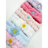 Multiple pastel spa headbands with daisy details displayed together