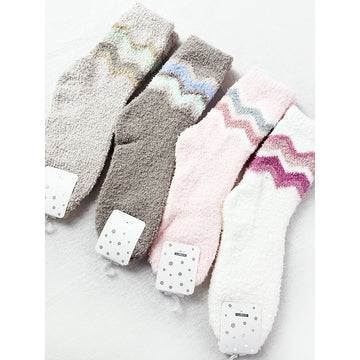 Assorted Love and Repeat plush socks in neutral and pastel colors with chevron patterns