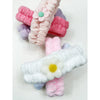 Stacked spa headbands with daisy embellishments in pastel shades