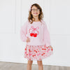 Young girl modeling a coordinating pink outfit and velvet pearl bow accessory