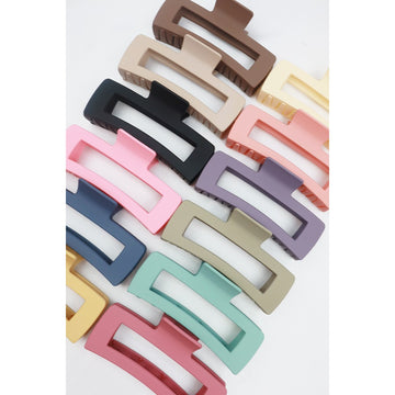 Assorted Love and Repeat rectangle hair claws lined up in multiple matte colors