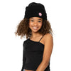 Girl wearing a black knit beanie with a small happy face patch