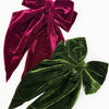 Side view of a velvet long tail bow clip showing texture and shape