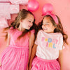 Two young girls celebrating in pink birthday shirts and coordinating tutu skirts