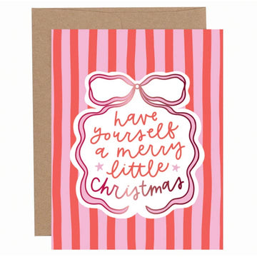 Red and pink striped Christmas greeting card with a bow illustration and hand-lettered “Have yourself a merry little Christmas” text, shown with a kraft envelope