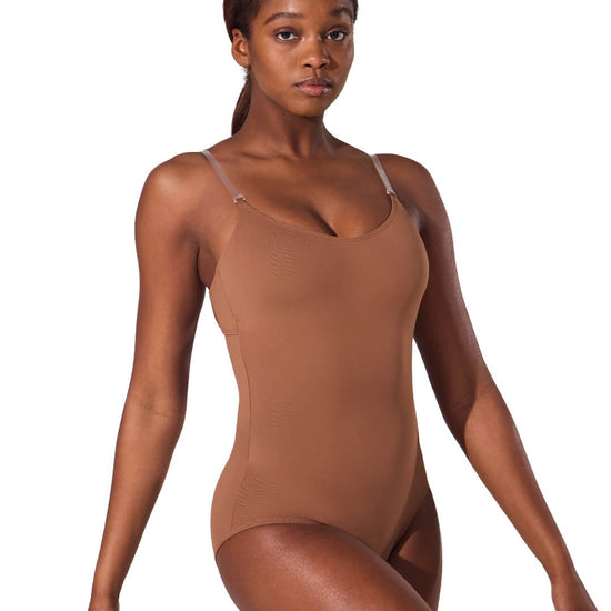 Model wearing a mocha camisole foundation leotard with clear adjustable straps and scoop front