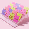 Multiple stud earrings arranged on stacked pink, purple, and yellow display cards.