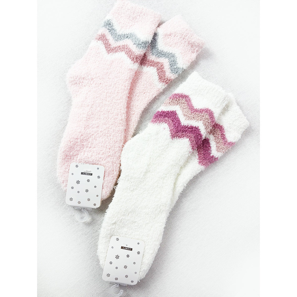 Pink and white Love and Repeat plush socks with colorful chevron patterns