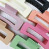 Assorted matte rectangle hair claw clips in neutral and pastel colors arranged together
