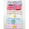 Assorted daisy spa headbands arranged side by side