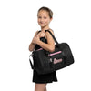 Young dancer holding a black dance duffel bag with shoulder strap