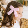 Close-up of pink velvet pearl hair bow worn in a young girl's hair