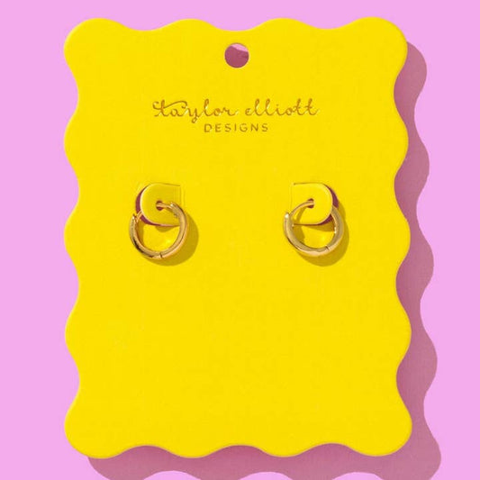Gold huggie earrings displayed on a bright yellow scalloped backer card with Taylor Elliot Designs branding.