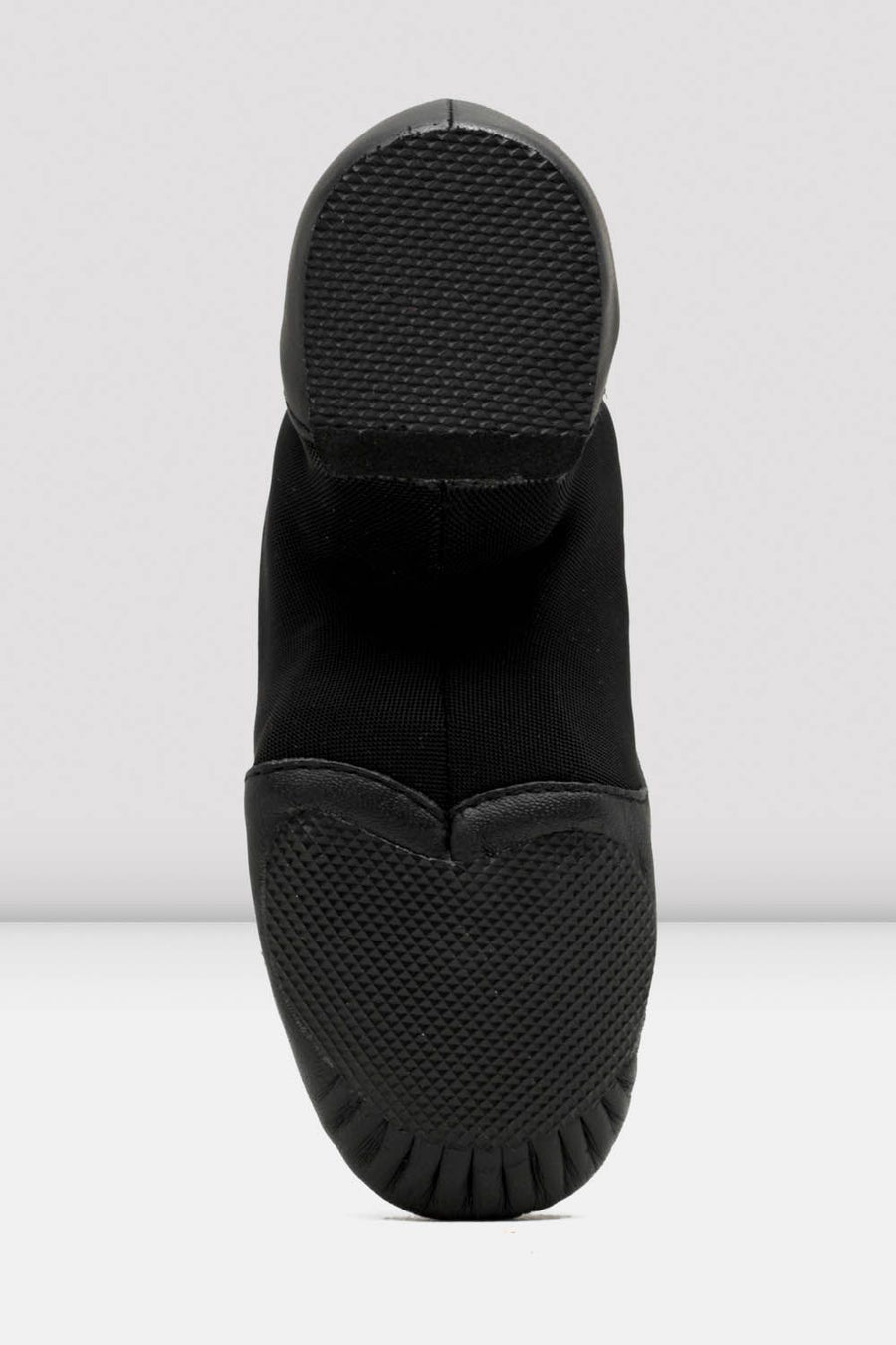 Black slip-on shoes with textured sole on a white background