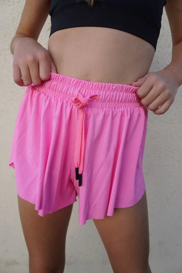 Close-up of dancer wearing a bright pink flutter skort with built-in shorts