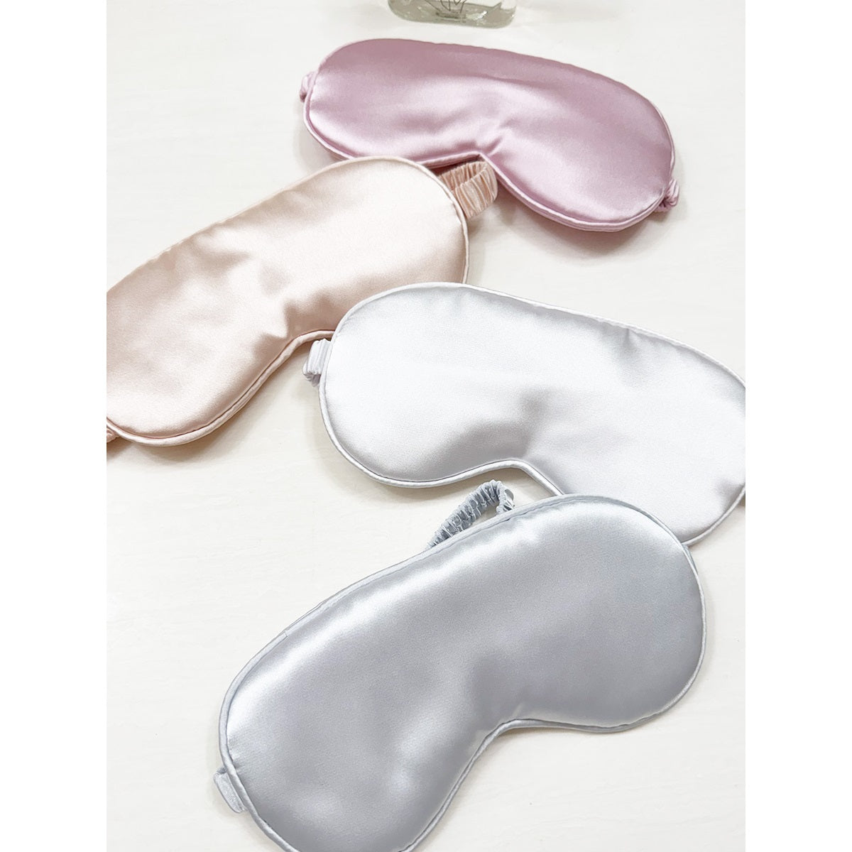 Assorted Love and Repeat satin sleeping eye masks arranged together