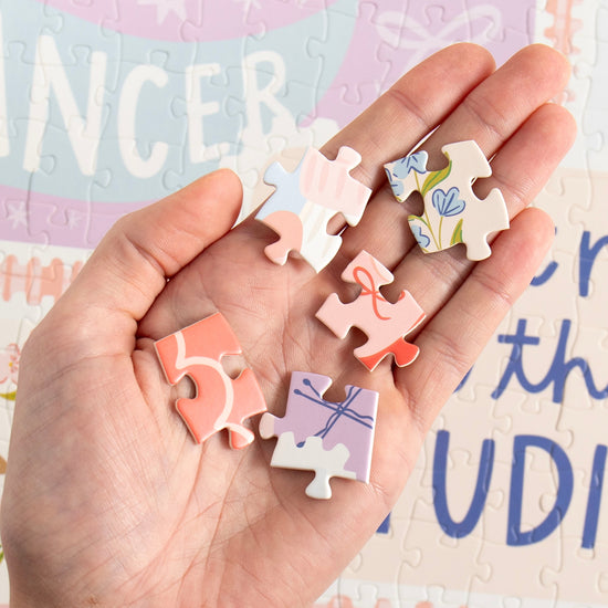 Hand holding pieces of the Dance It Out jigsaw puzzle during assembly