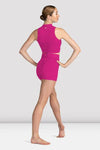 Back view of dancer wearing a pink crop top and matching shorts with hands on hips