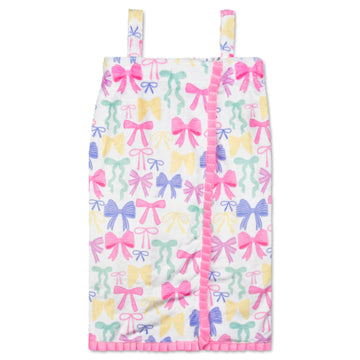 A white baby bib or pouch featuring an all-over pastel bow print in pink, blue, yellow, and mint green, with pink ruffle trim along the front edge and straps, shown against a plain white background.