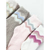 Close-up of assorted Love and Repeat plush socks in gray, pink, and white
