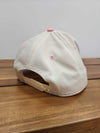 Side and back view of a cream and pink baseball cap showing the adjustable snapback closure