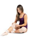 Dancer seated on the floor wearing nude gel knee pads during stretching