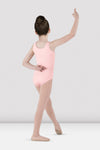 Child dancer wearing light pink tank leotard posing in dance position