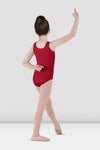 Child dancer wearing red tank leotard posing in dance stance