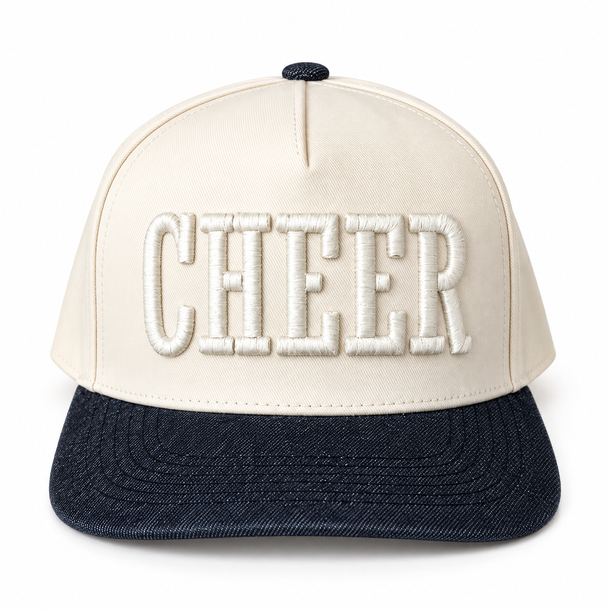 A structured snapback cap with an off-white crown and a dark navy denim-look brim. The word 'CHEER' is embroidered in large, raised white letters across the front.