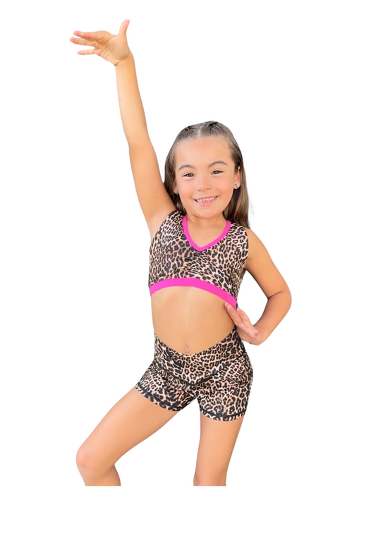 Young dancer wearing patterned V-waist dance shorts with coordinating top, posing in a dynamic stance.