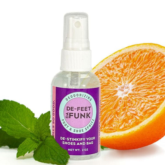 Bottle of deFEET da FUNK deodorizing foot and shoe spray with orange slice and mint leaves