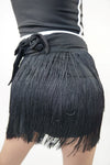 Close-up back view of black wrap fringe skirt showing layered fringe detail.