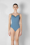 Child model wearing a light blue camisole leotard, shown from the front.