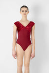Adult model wearing a red short sleeve leotard, shown from the front.