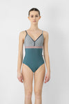 Model wearing teal and pink camisole leotard front view