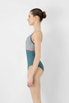 Model wearing teal and pink camisole leotard side view