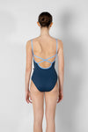 Child model wearing a navy camisole leotard, shown from the back.