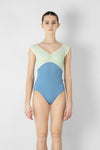 Adult model wearing a two-tone cap sleeve leotard, shown from the front.