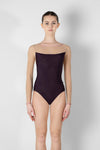Adult model wearing a dark tank leotard with mesh back, shown from the front.