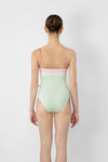 Model wearing light green and pink camisole leotard back view
