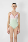 Model wearing light green and pink camisole leotard front view