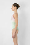 Model wearing light green and pink camisole leotard side view