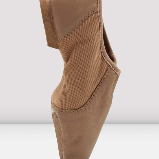 Side profile of a tan slip-on leather jazz shoe standing upright.