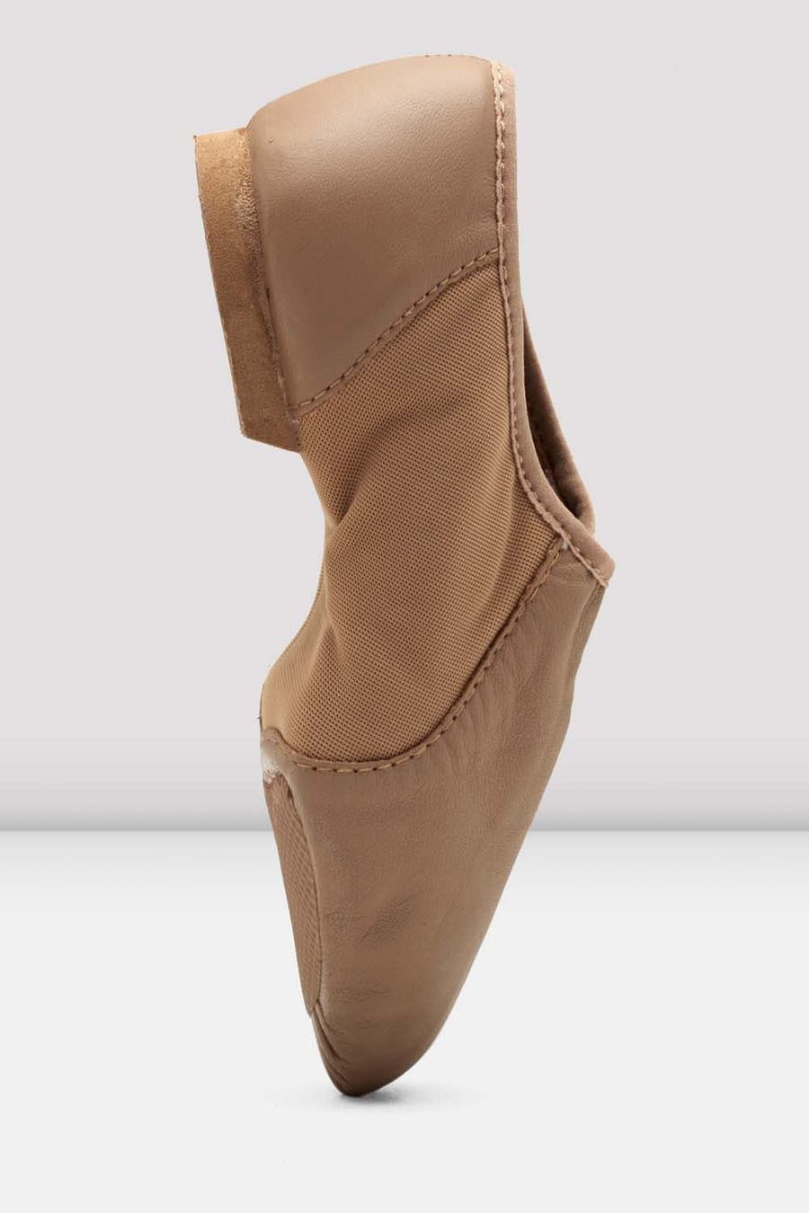 Side profile of a tan slip-on leather jazz shoe standing upright.
