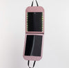 Pink LED folding double mirror with illuminated lights around the top mirror, hanging vertically.
